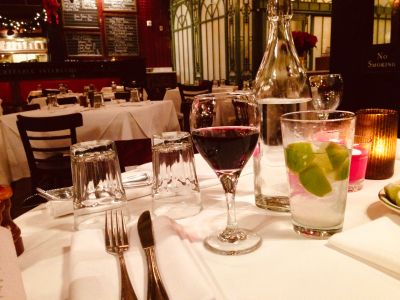 Elegant table setting with wine and cocktail in a cozy restaurant.