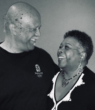 An elderly couple sharing a joyful moment, smiling warmly at each other.