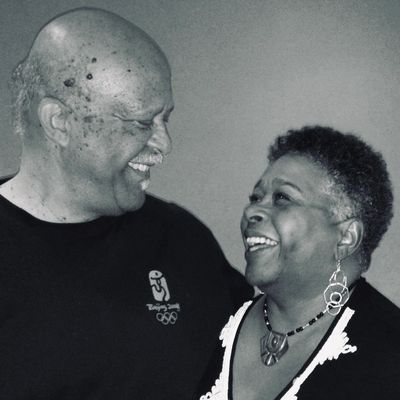 An elderly couple laughing and sharing a joyful moment together.