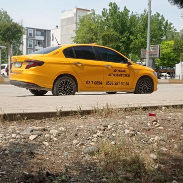 Adıyaman Altınşehir taksi sarı renkte ve yanlarda yazılar var.