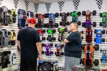 Two men looking at the collection of remote control cars