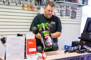 A man looking at an RC truck at the cash counter