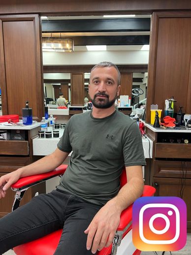 Man sitting in a barber chair in a salon.