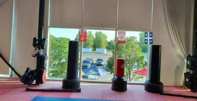 Indoor martial arts training area with equipment and mats.