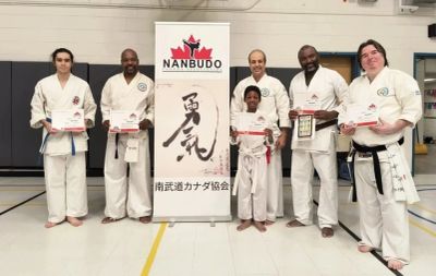 Group of martial artists with certificates and awards.