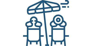 Two chairs under a beach umbrella with wind blowing.