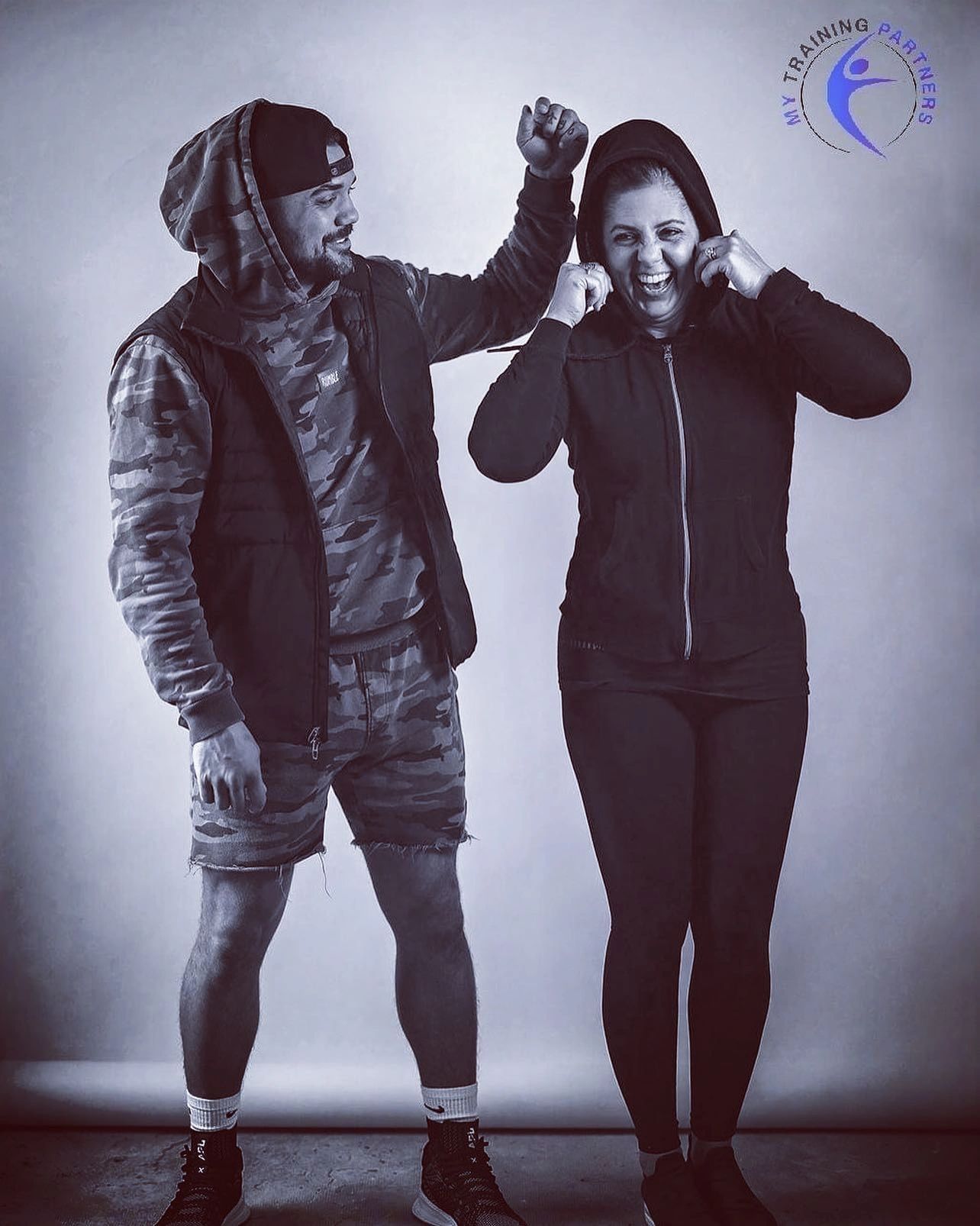 two fitness coaches, Natalie and Ryan laughing together after a training session.  Mom and son team.