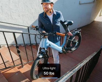 Man carrying a lightweight bicycle up stairs.