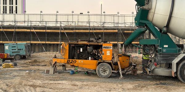 Construction site with concrete mixer and machinery.