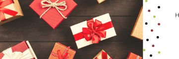 Multiple gift boxes with red ribbons on a wooden surface.