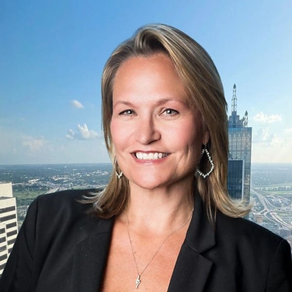 Smiling woman with blonde hair in a black blazer.
