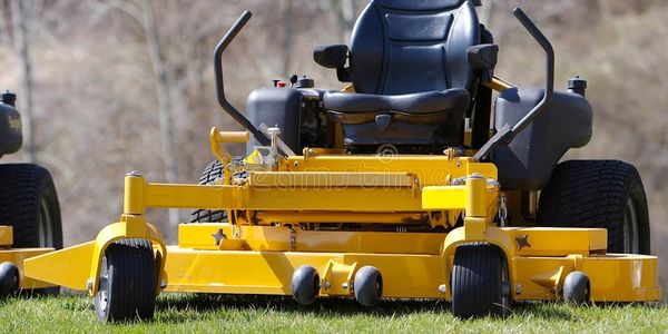 A yellow zero-point lawn mower with no driver.