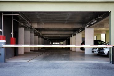 Entrance to an underground parking garage with a barrier gate.