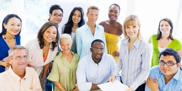 Diverse group of professionals smiling in a bright office.