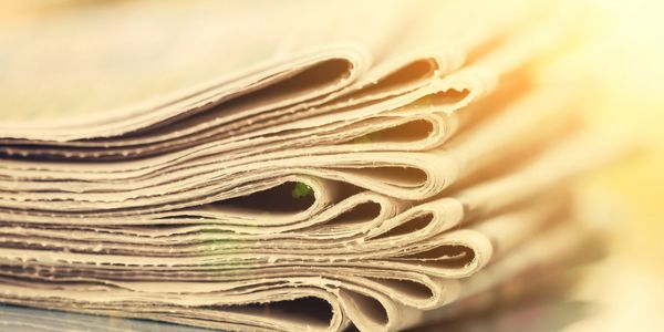 Close-up of folded newspapers stacked together.