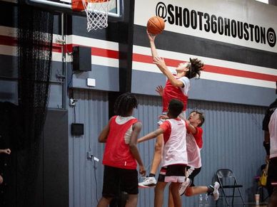 "Young basketball players training in a high-tech gym at Shoot 360 Houston, practicing shooting, dri