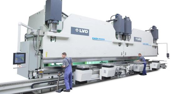 Two workers operate a large industrial press brake machine.
