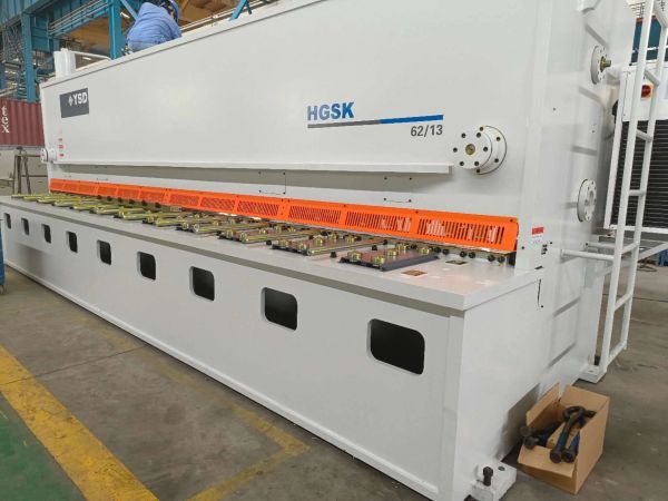 Large white industrial machine with HGSK branding in a factory.