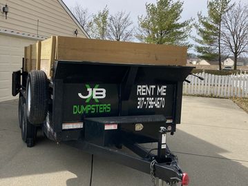 A picture of a dumpster in a driveway 