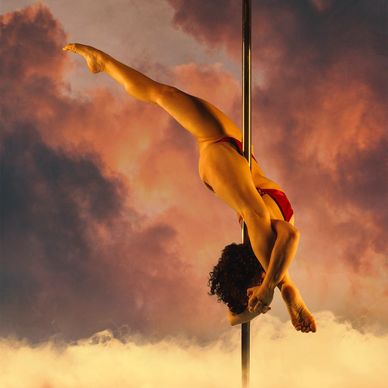 Advanced pole dance move called bird of paradise. Splits and shoulder flexibility used. Pole dancer.