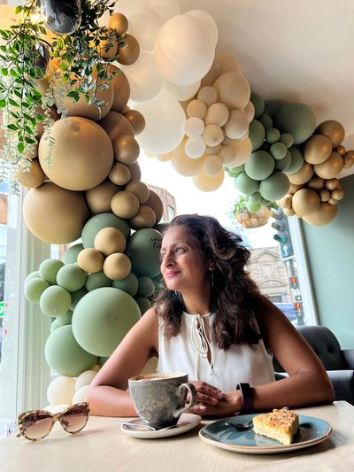 Portrait picture of Babita drinking coffee from a coffee shop