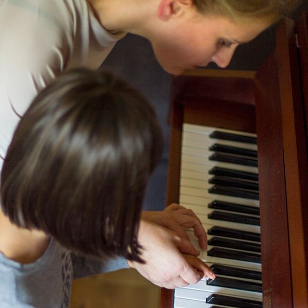 Piano teacher explains to the pupil each piano note - piano lessons in North London