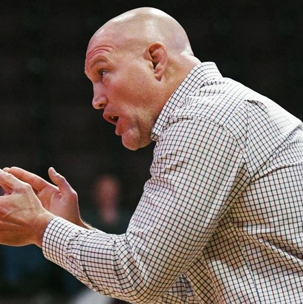 A bald man passionately speaking or coaching.
