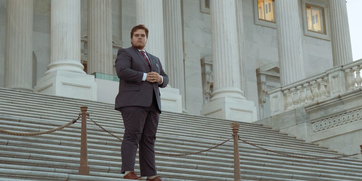 Our President Aidan Haggard stands in front of the US Senate with a suit and tie. 