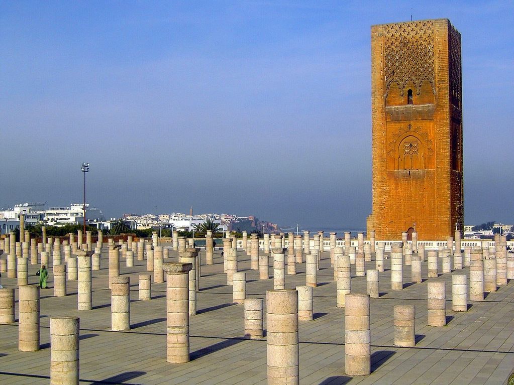 Ruins with tall stone pillars and a tower.