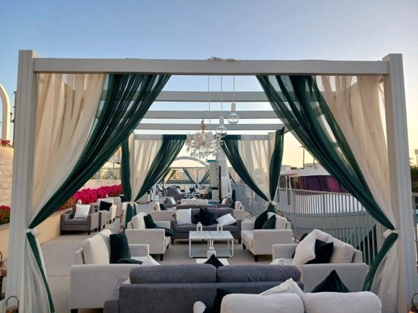 Outdoor lounge with draped curtains and modern seating.