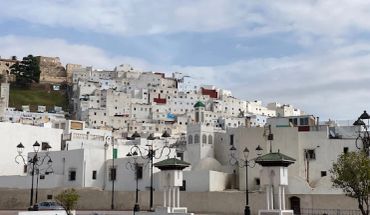 White buildings on a hillside under a cloudy sky.