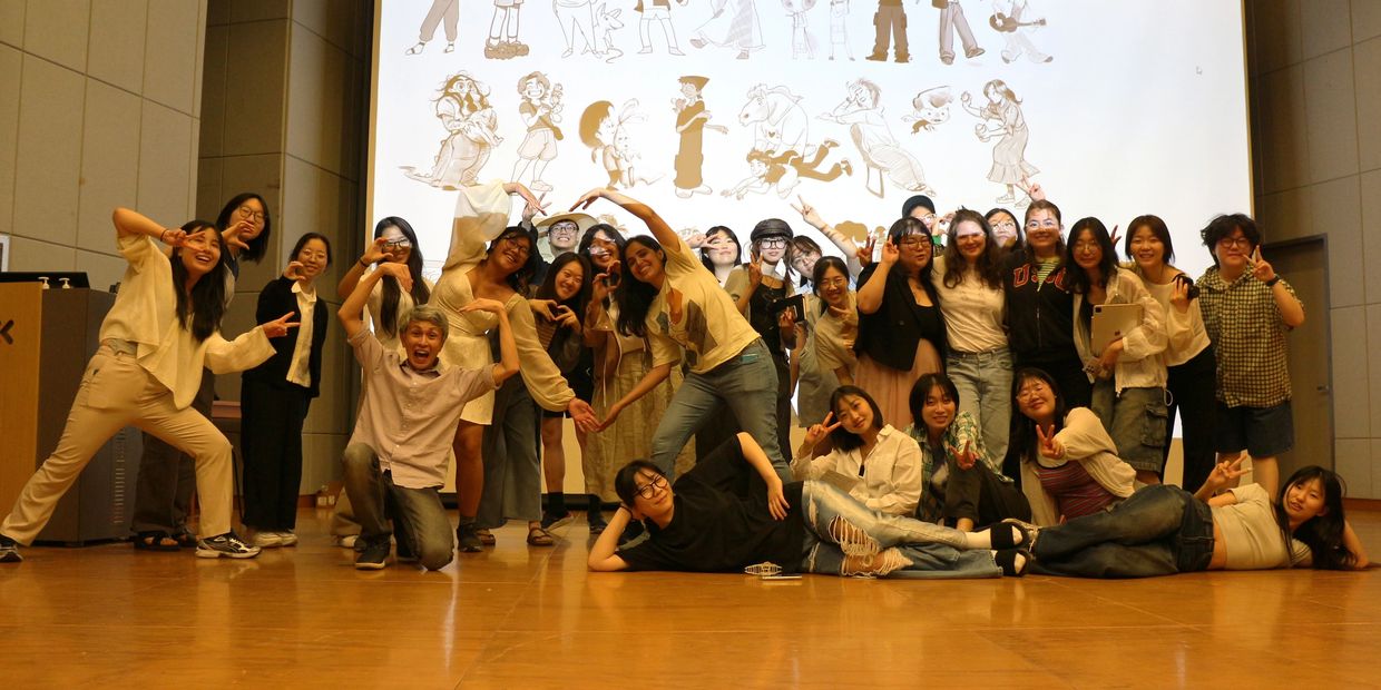 A lively group posing playfully on stage with cartoon drawings projected behind them.