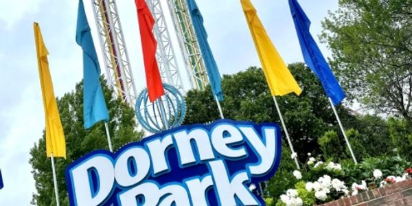 Entrance sign to Dorney Park with colorful flags.