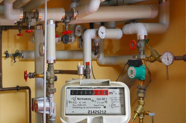 Alt Text: Close-up of a water measurement meter with pipes and gauges.