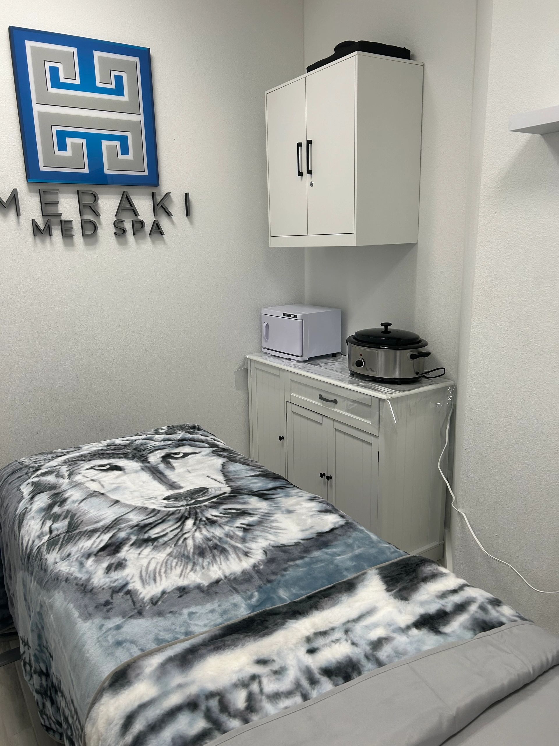 Cozy spa treatment room with wolf-themed blanket and warming devices.
