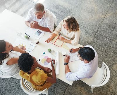 Group of diverse municipal financial professionals collaborating about funding at a meeting table.