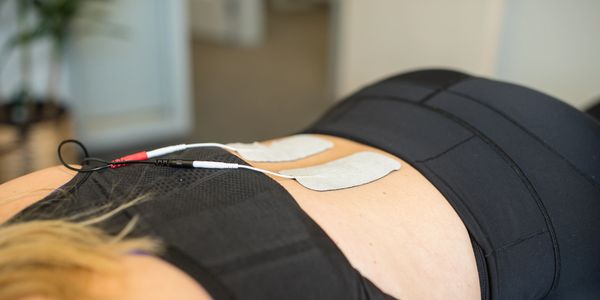 Electrical stimulation therapy placed on the lower back of a patient for lower-back pain relief