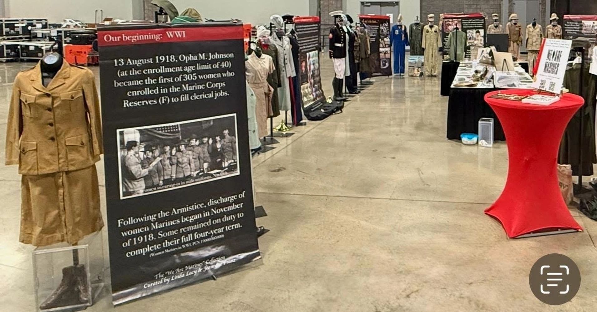 WWI Marine Corps women's uniforms and historical display in an exhibition hall.