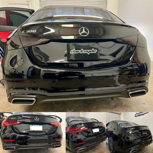 Black Mercedes C300 with darkstyle license plate in a garage.