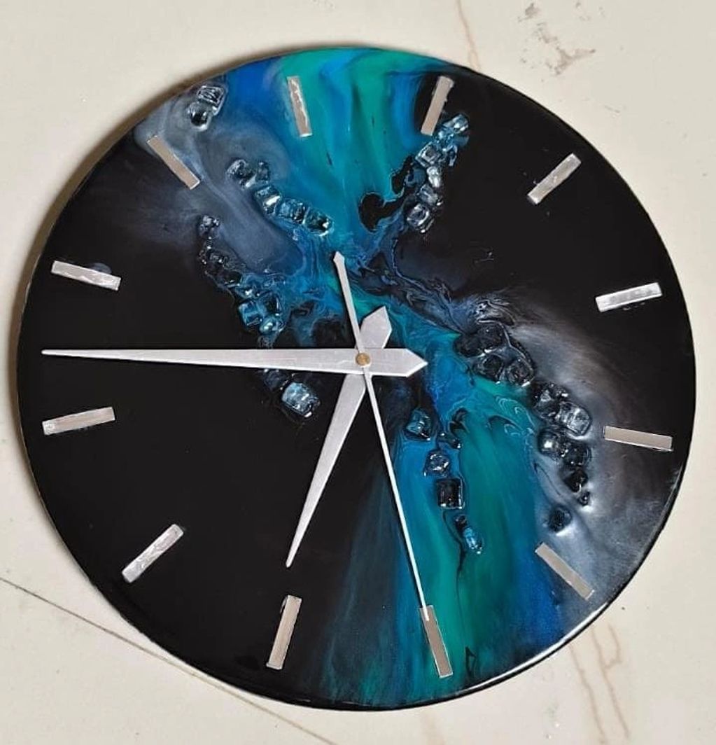 this handcrafted resin wall clock, featuring a mesmerizing blend of deep black, aqua blue.