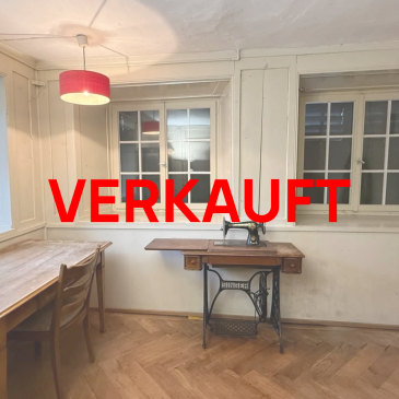 Old room with vintage sewing machine and "VERKAUFT" text.