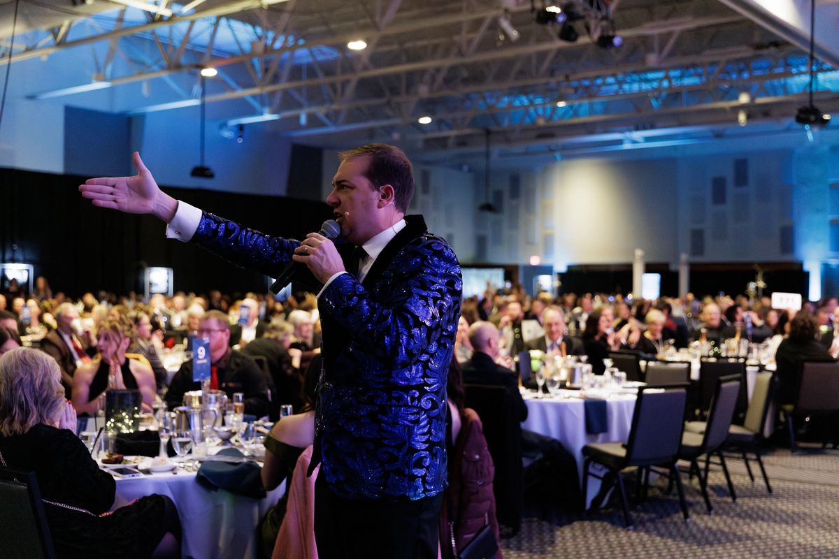 Benefit auction emcee hosting a charity gala program on stage