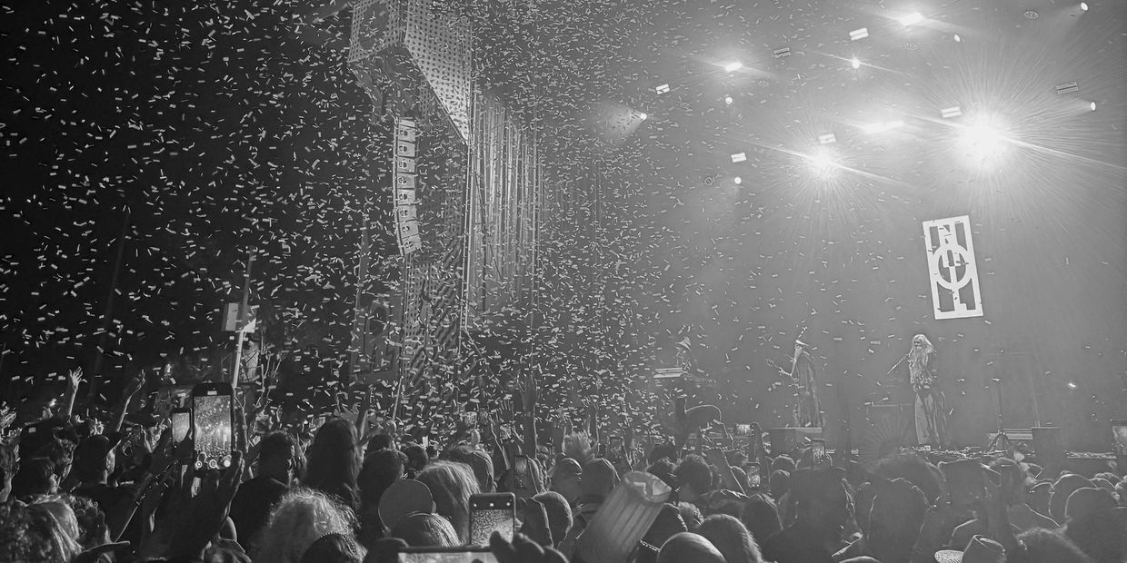 Black and white photo of a concert with confetti and a crowd.