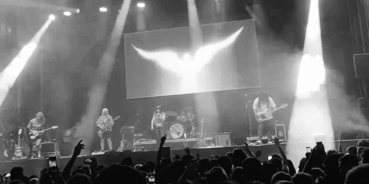 Black and white photo of a band playing on stage with a crowd.