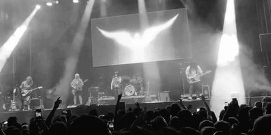 Black and white photo of a live concert with a stage and musicians.