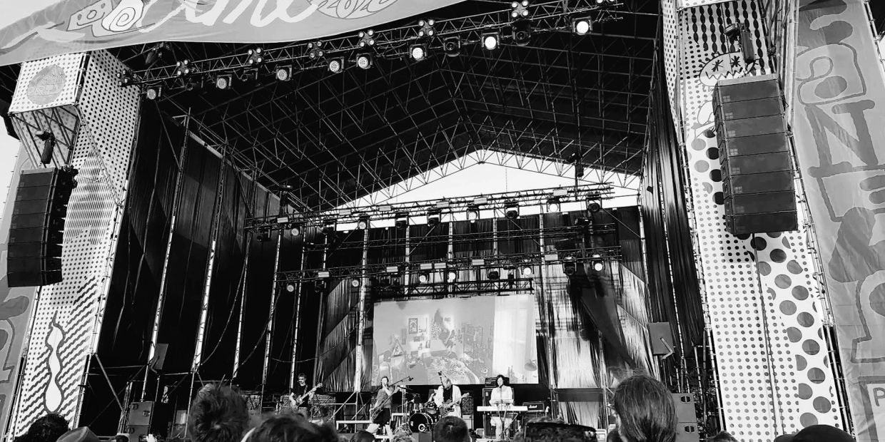Black and white photo of a live band on stage with a crowd in front.