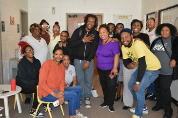 A diverse group of people smiling and posing together indoors.