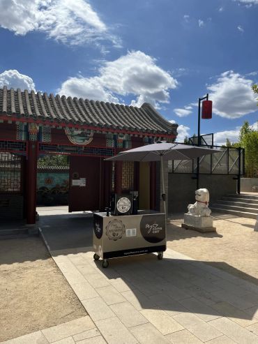 Traditional architecture with a food cart under a sunny sky.