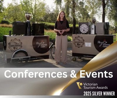 Woman standing between two coffee carts promoting conference and event services.