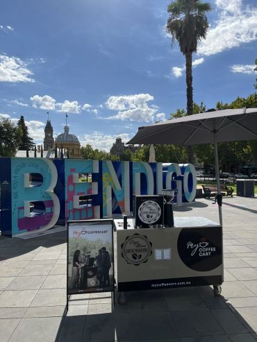 Coffee cart outside the Bendigo sign on a sunny day.